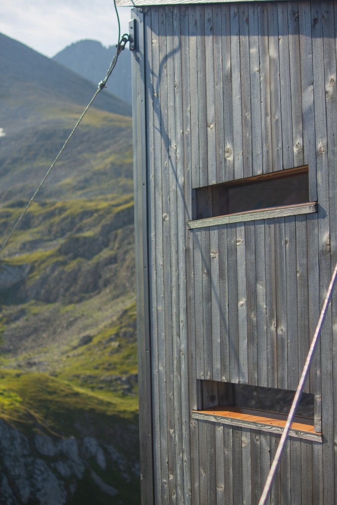 the outside of the hut from outside looking in the direction of the arrival trail showcaseing two of the windows